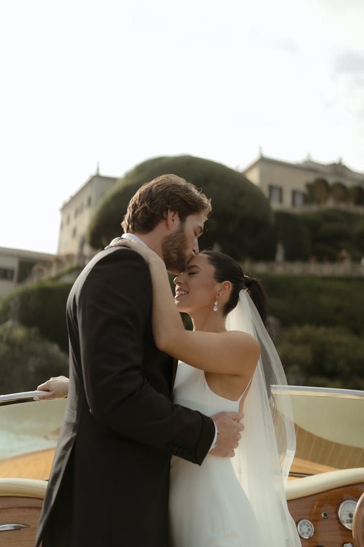 newlyweds on a boat on the shores of Lake Como